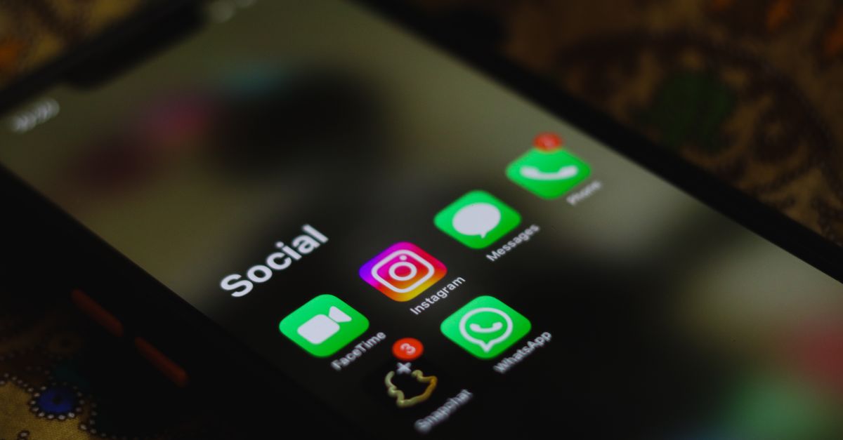 A close-up shot of smartphone displaying social media apps icons on screen.